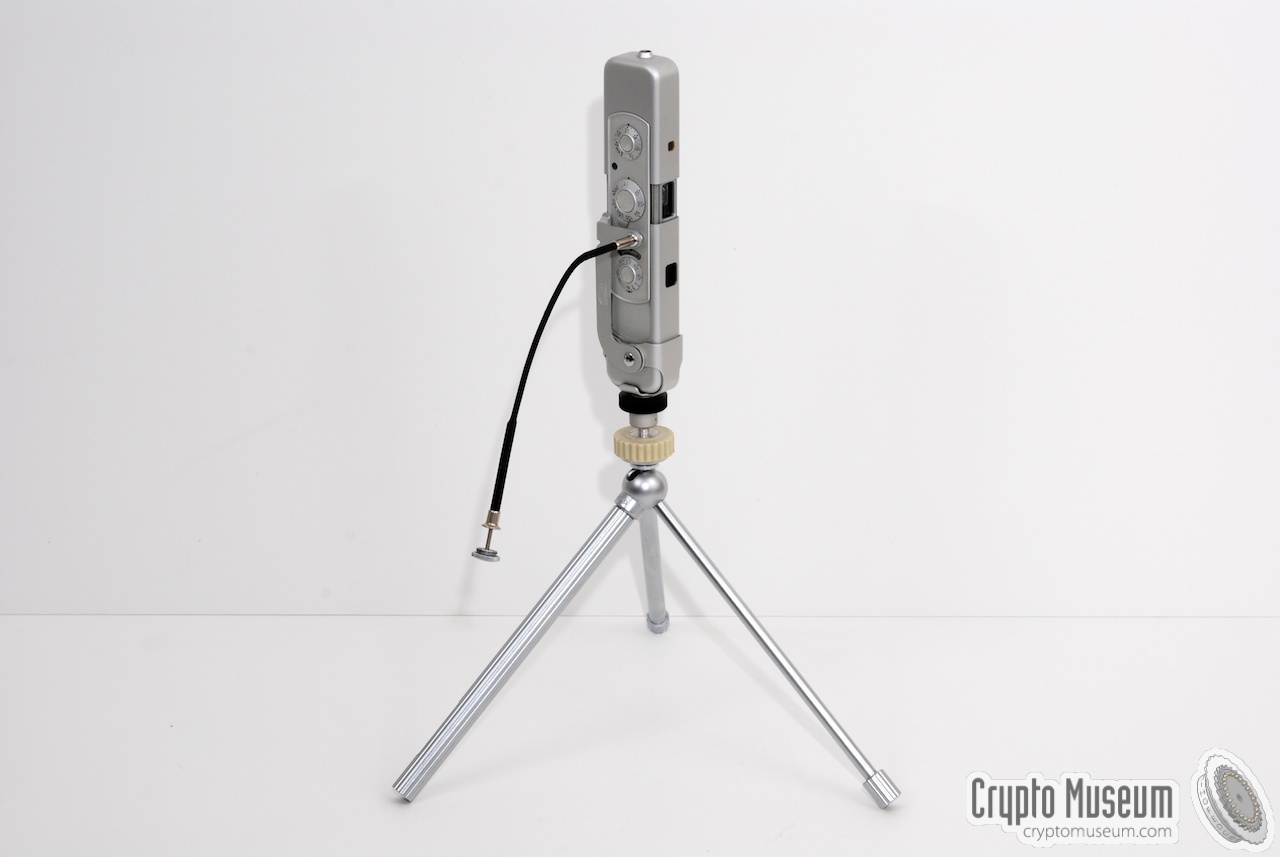 The tripod with a Minox C camera mounted on top of it. The camera is ready for use and is operated with the shutter release cable.