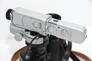 A Minox C attached to the lens of a pair of Agfa binoculars.