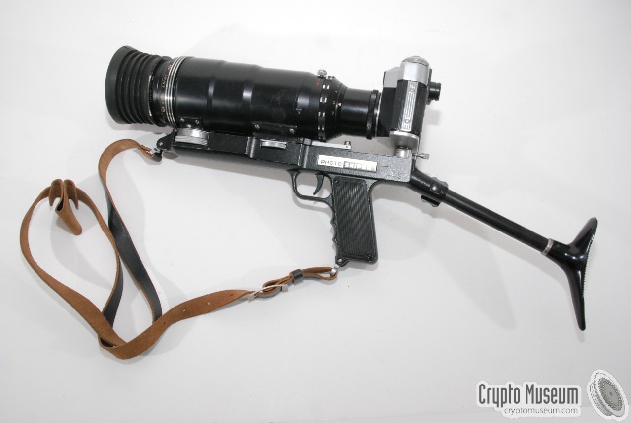 The complete Sniper Camera, showing the Zenith, the lense, the 'rifle' and a leather carrying strap.