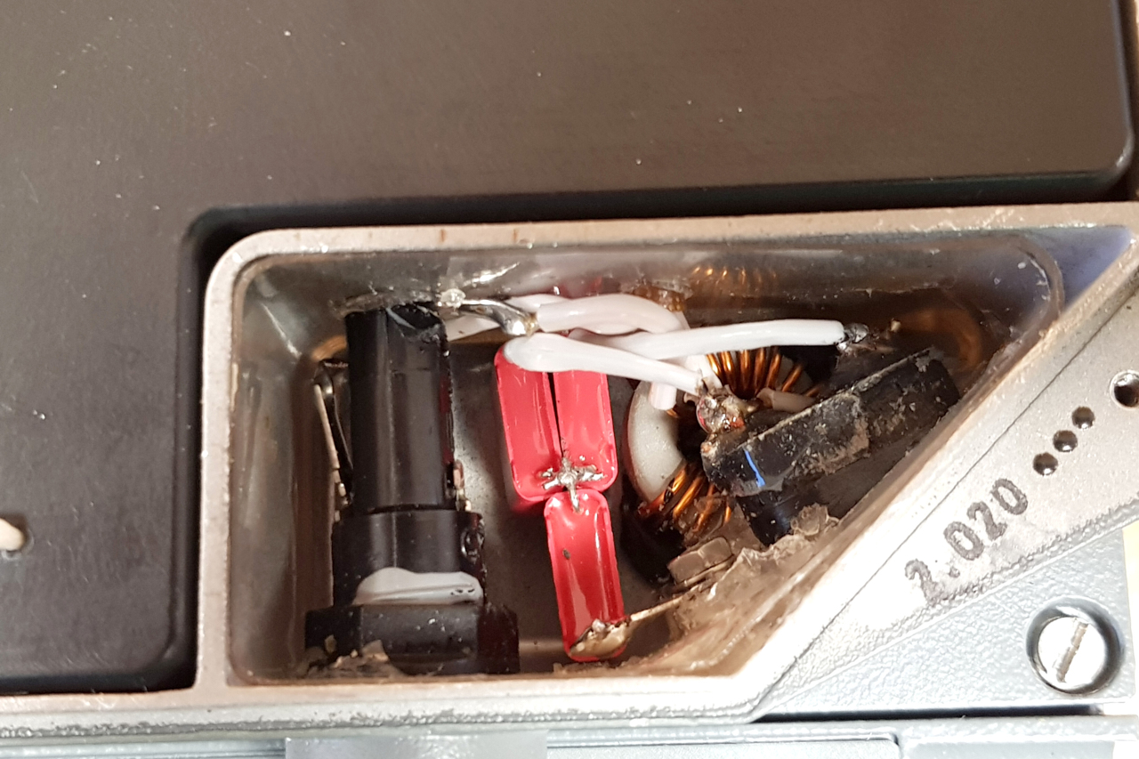 Mains receptacle compartment with new capacitors. Photograph by Karsten Hansky [3].
